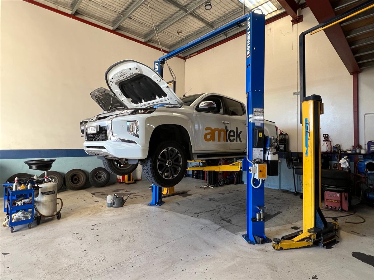 An Amtek Australia ute up on a hoist with the bonnet open