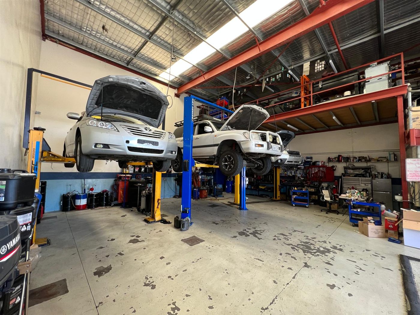 Toyota Camry, Land Cruiser and a boat motor being serviced in the workshop